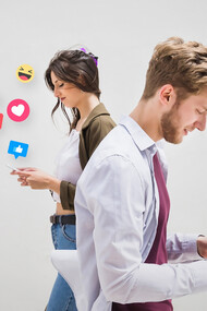 A group of people walking on the pavement, each absorbed in their phones, illustrating the addictive nature of social media