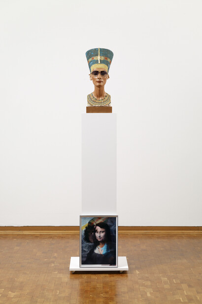 Isa Genzken, Nofretete – Das Original, 2012, Nefertiti plaster bust with sunglasses on wooden base, wooden plinth and colour photograph in aluminium frame, 184x50.5x40 cm, Privatsammlung Rheinland, courtesy Galerie Buchholz/VG Bild-Kunst, Bonn 2023 / photo: Sascha Fuis. Courtesy Neue Nationalgalerie, Berlin