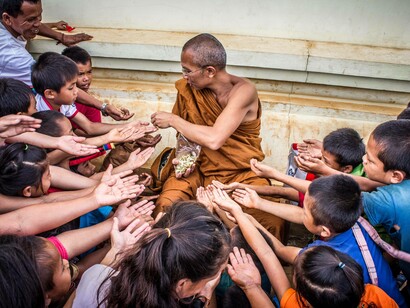 Buddhist monk teaching children to recieve 