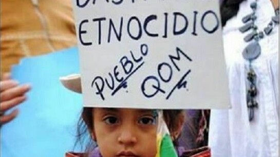 Una niña sostiene una pancarta en una manifestación del Pueblo Qom