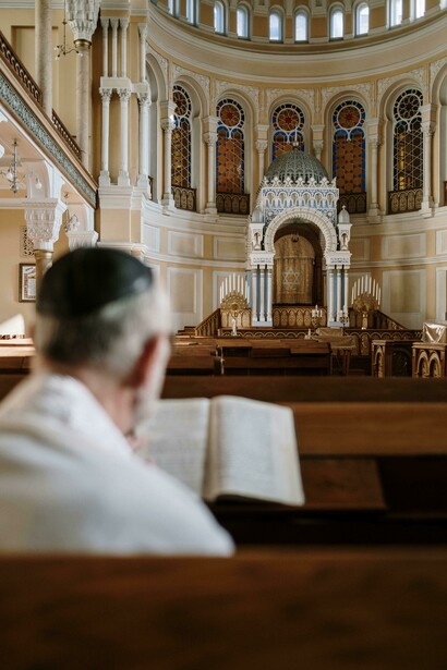 A man wearing a kippah, praying and reading the Bible