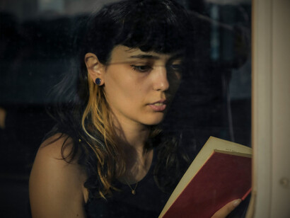 Donna che legge un libro in treno: "...alcuni collaboratori di Peng, all’insaputa della gente, piazzarono i primi dieci libri contenenti ognuno 1000 franchi in contanti" 