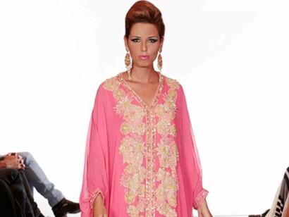 A model radiating beauty in a pink caftan from fashion designer Albert Oiknine