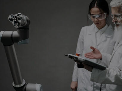 A woman and man working in a lab with robotic technology, showcasing cutting-edge innovation