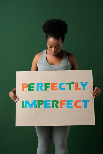 Woman gazing down at a sign 'perfectly imperfect'