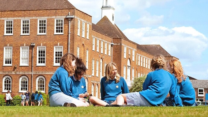 Jóvenes de uniforme en el jardín de un colegio privado