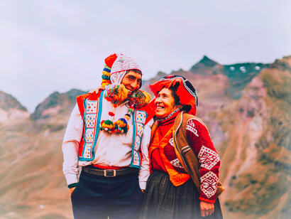 A Peruvian couple smile at each other in traditional clothes in Perú