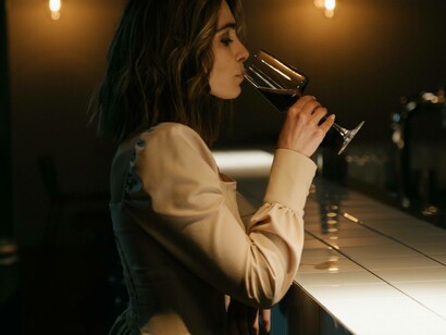 A woman sipping her red wine as she appreciates the value of the single life