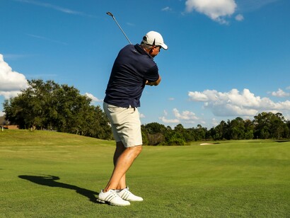 A golfer finishing with a confident swing, reflecting the rewarding experiences found on French Lick's championship fairways