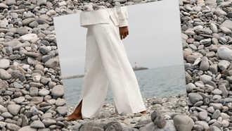 Barefoot on the rocks, a model steps into herself grounded in reflection and free to feel