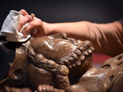 Dusting a replica of King Johns tomb which resides in Worcester Cathedral for the opening of Magna Carta: Law, Liberty, Legacy at the British Library. Photography © Clare Kendall