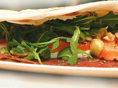 Piadina romagnola con bresaola, mozzarella, pomodori, rucola e olive
