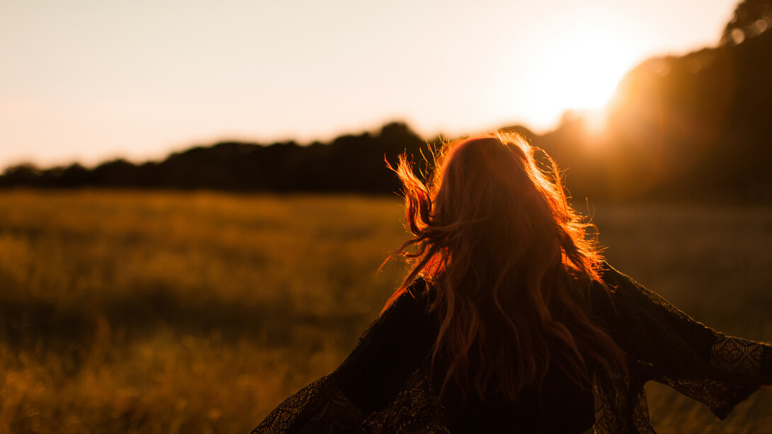 Mujer recorre una pradera sola, como símbolo de autodescubrimiento, en Parliament Hill, Londres, Reino Unidos