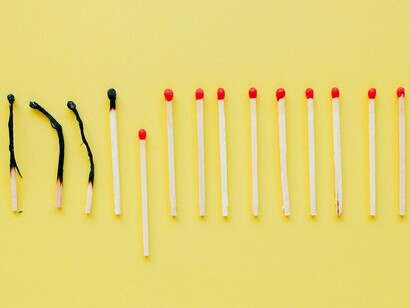 Blackened matchsticks lying near pristine ones, conveying the silent progression from effort to exhaustion