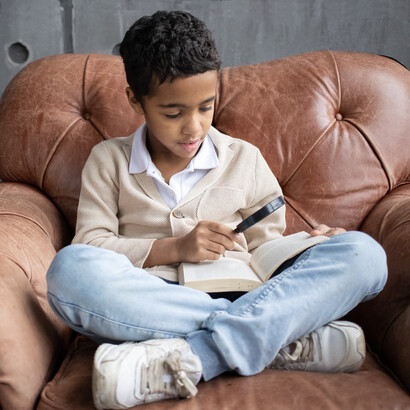 Criança concentrada com livro de história
