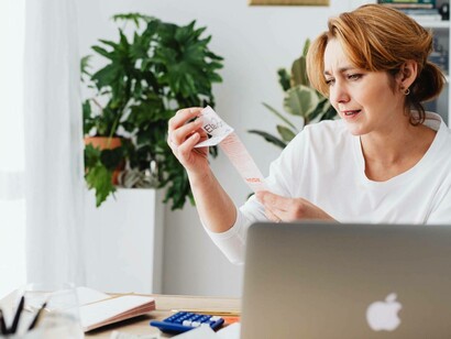 A woman looks in disbelief at a bill
