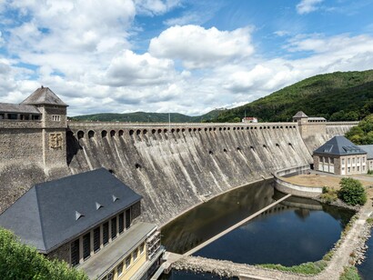 A hydroelectric dam surrounded by forests and water, reflecting the importance of coordinated planning in managing essential resources