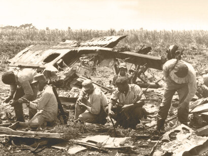 Soldados de las Fuerzas Armadas Revolucionarias de Cuba examinan los restos de un avión derribado en Bahía de Cochinos, 1961