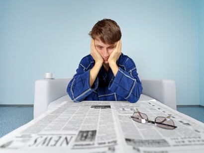 Un joven busca ofertas de empleo en un periódico