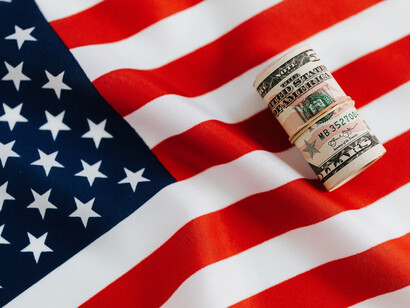 US flag with a roll of money
