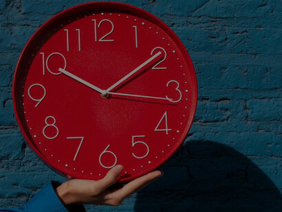 A woman holding a wall clock, surrounded by mesmerizing complexity diagrams and clock faces, offering a visual representation of the multifaceted nature of timepieces and temporal intricacies