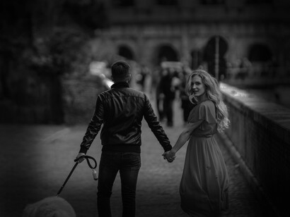 A man and a woman in love, walking their dog on the streets of Rome, Italy