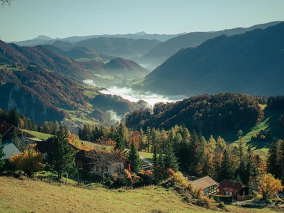 Rolling hills dotted with houses and trees show a lived-in landscape, where daily rhythms matter more than landmarks or quick visits
