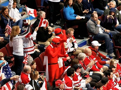 A pair of passionate Canadian fans enjoy their beers, fully embracing the game-day spirit