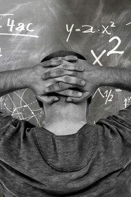 A student staring at the problem on the board at his university, unsure of the answer
