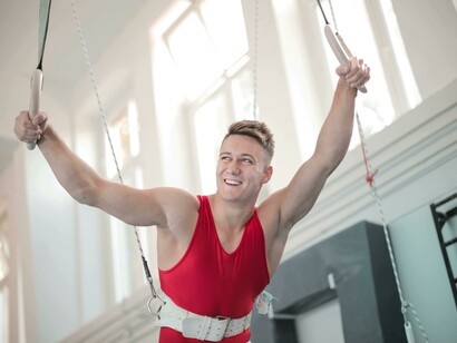 With focus and hard work, a young male gymnast stands ready between the bars, representing consistency and dedication