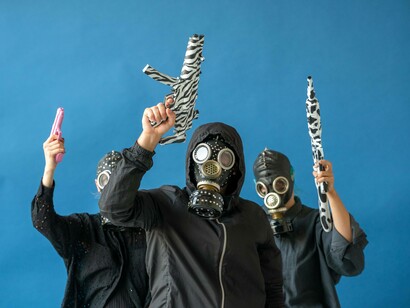 Anonymous protestors holding up toy guns
