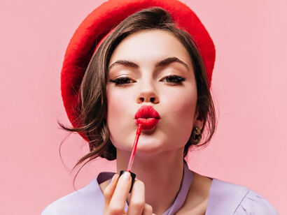 Young woman with vibrant red lipstick and a chic beret, embodying confidence and small luxuries in challenging times