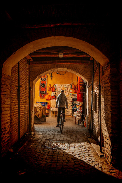 A historic archway framing one of the narrow streets of the Marrakesh medina, Morocco