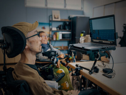 A diverse group of people with varying abilities working together in a small office