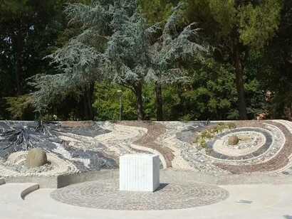 “Le chaos et la source de vie” by Rahir Claude: he conceives the work dedicated to peace as a landscape in stone and water. He creates a circular space divided into two large semi-circles, one of which constitutes the entrance and offers a privileged point of view on the entire environment