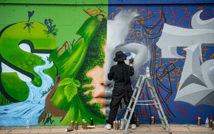 An artist creating graffiti on a wall