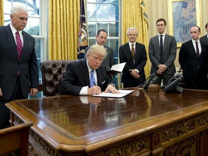 Trump firmando sus primeras órdenes como presidente