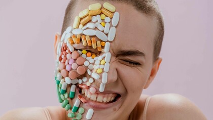 Happiness on a person's face that also has a collection of pills