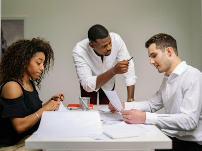 A workplace interaction with disengaged team members, representing environments where disagreement feels unsafe