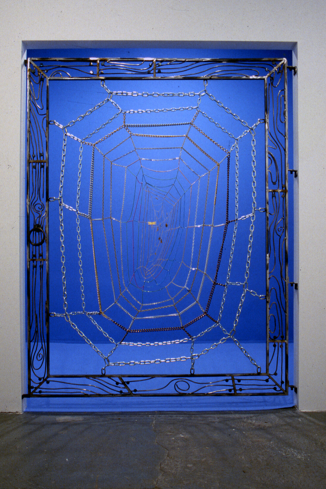Jim Hodges, Untitled (Gate), 1991. Steel, aluminum, copper, and brass chain with blue room. 78 x 60 x 2 in. © Jim Hodges.