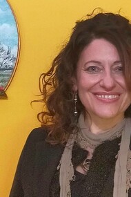 Nora Art next to one of her painted pieces