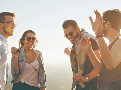 Persone che ridono e parlano tra loro al tramonto