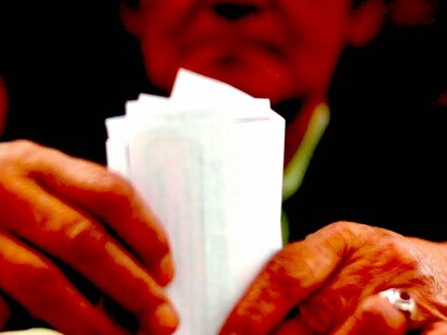 Una mujer deposita sus papeletas