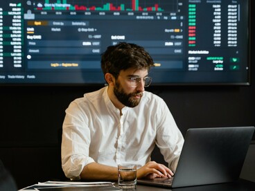 An investor analyzing stock charts, reflecting SpaceX's Nasdaq-100 milestone