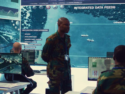 Military personnel working in a cyber security control room, monitoring multiple screens in a reconnaissance operations center