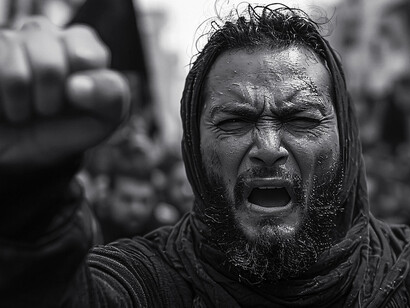 The determined expression on the man's face and his raised fist reflect a commitment to fighting for both individual rights and societal harmony, two ideals that must be carefully balanced