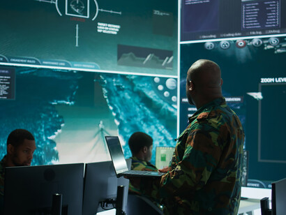 A cybersecurity team operates within an advanced military command center, monitoring digital threats in real time