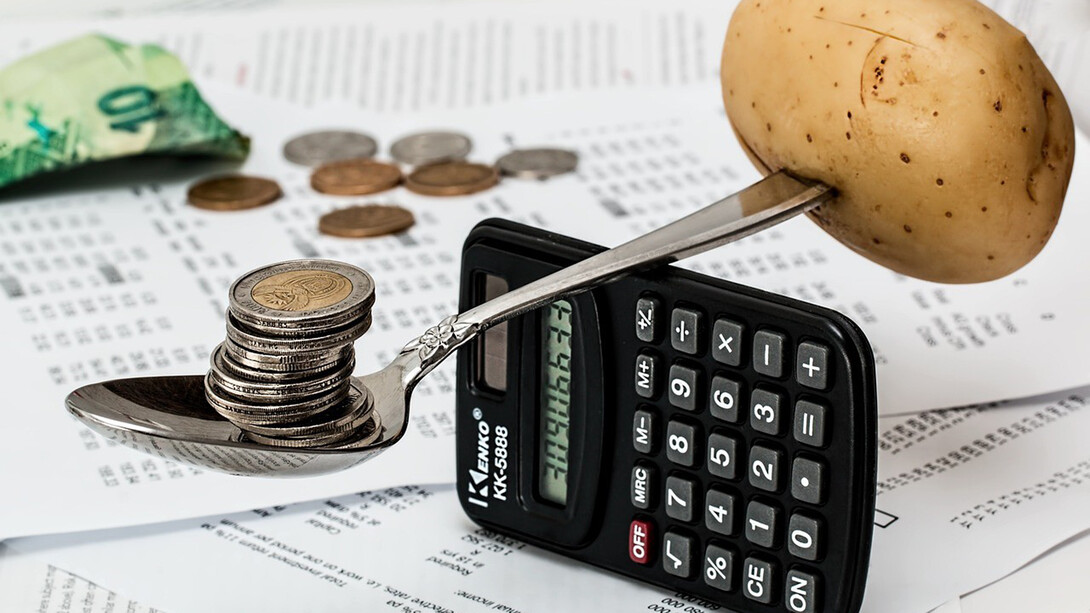 The image could feature a spoon balanced over a calculator, with a potato and money on either side, symbolizing the struggle with rising living costs and the need to budget and make ends meet