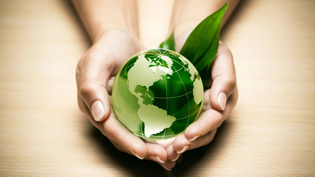 Manos sosteniendo un globo terráqueo: La «Revista de Ciencias Ambientales» es una publicación comprometida con las generaciones futuras