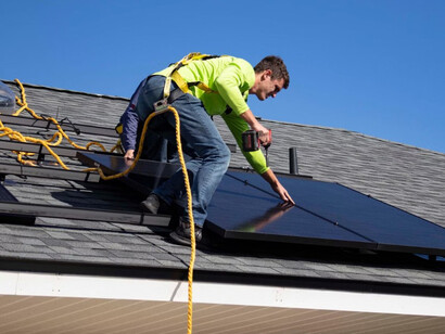 A man is installing solar panels on a rooftop